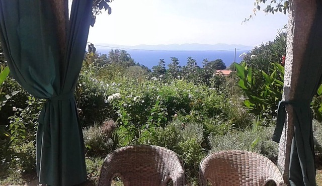 Sunset over Corsica. Detached house surrounded by greenery, sea view.
