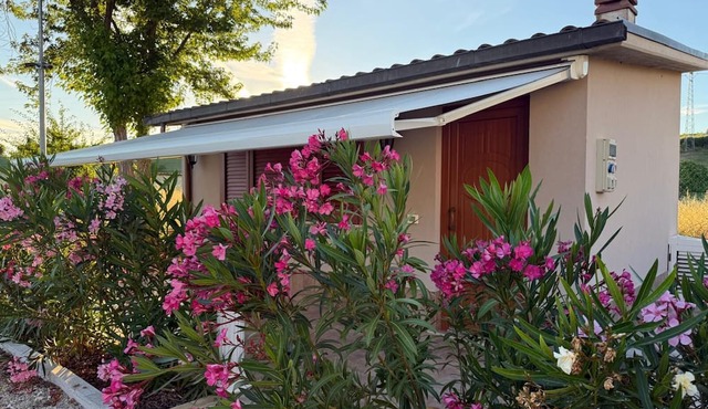 A guesthouse with a fireplace in the garden of a villa with a pool; the beach is 5 minutes away